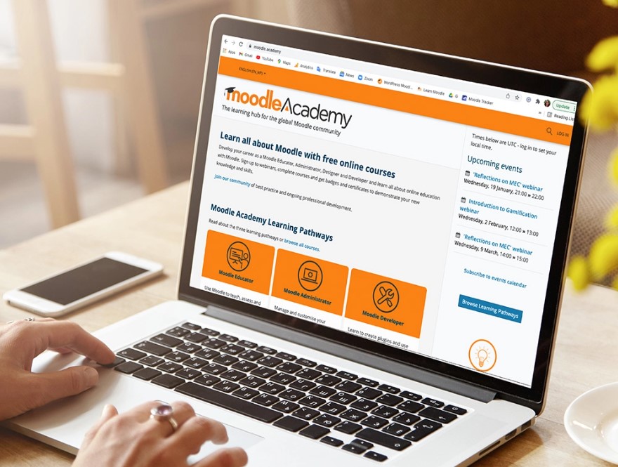 открытый ноутбук на странице сайта, который использует типовую CMS по типу Moodle и хостинг